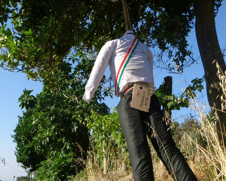 SAN GIOVANNI DI GERACE: UN FANTOCCIO CON TANTO DI FASCIA TRICOLORE APPESO COL CAPPIO AL COLLO SU UN ALBERO - 